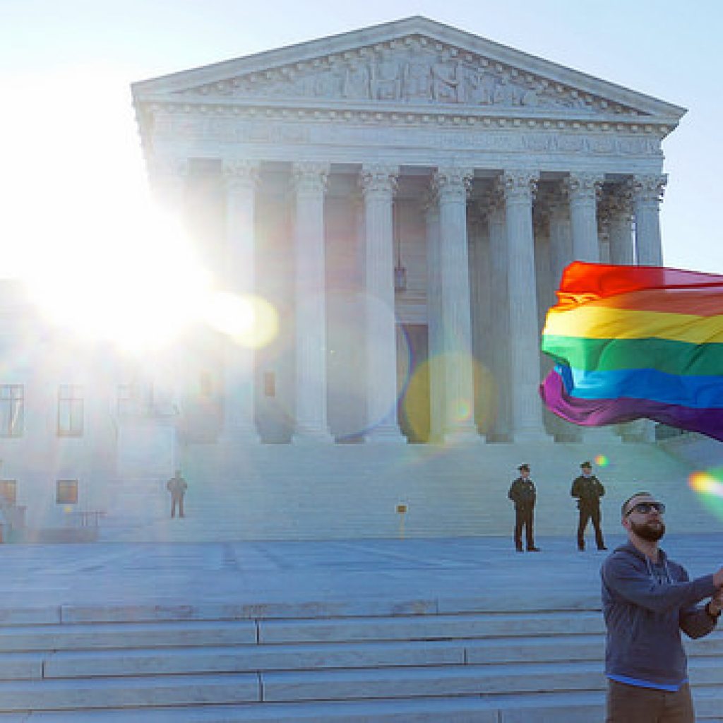 Man waves LGBTQ pride flag in front of Supreme Court